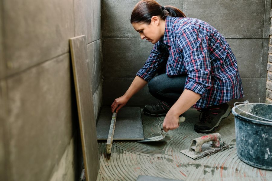 tiler working on a floor representing skilled trades