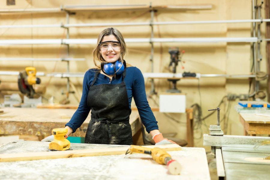 carpenter surrounded by woodworking tools and equipment