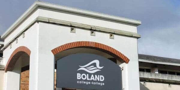 The entrance to Boland College with their signboard between two cream cement pillars